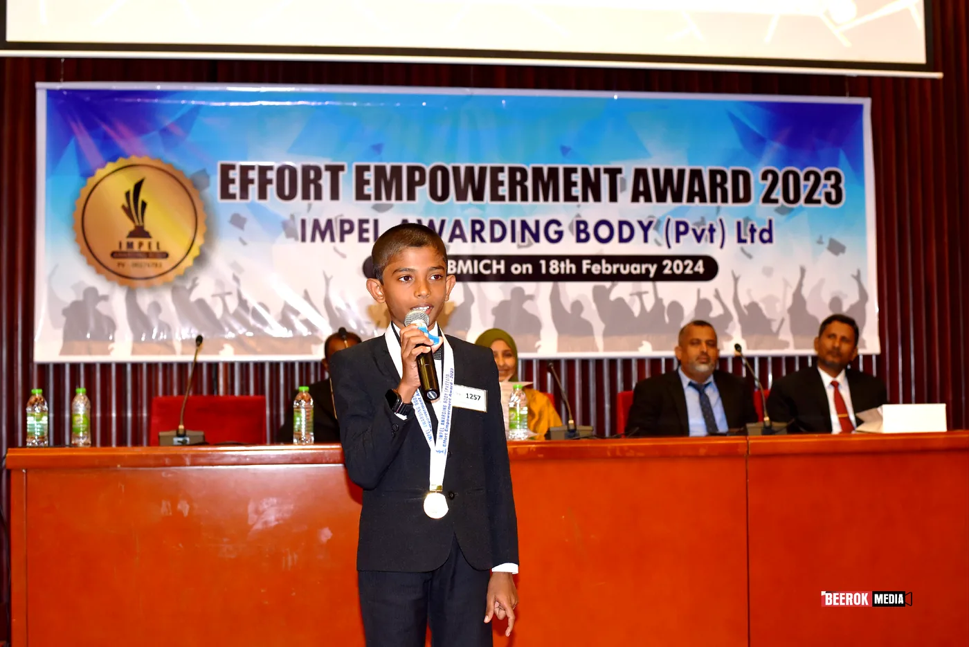 A young awardee speaking on stage
